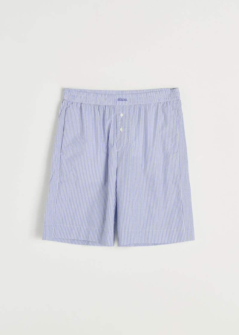 Et par løse, stribede boxershorts hænger mod en hvid baggrund. Shortsene er blå- og hvidstribede med en elastisk linning, to knapper, og ordet "#BARI" broderet på midten.