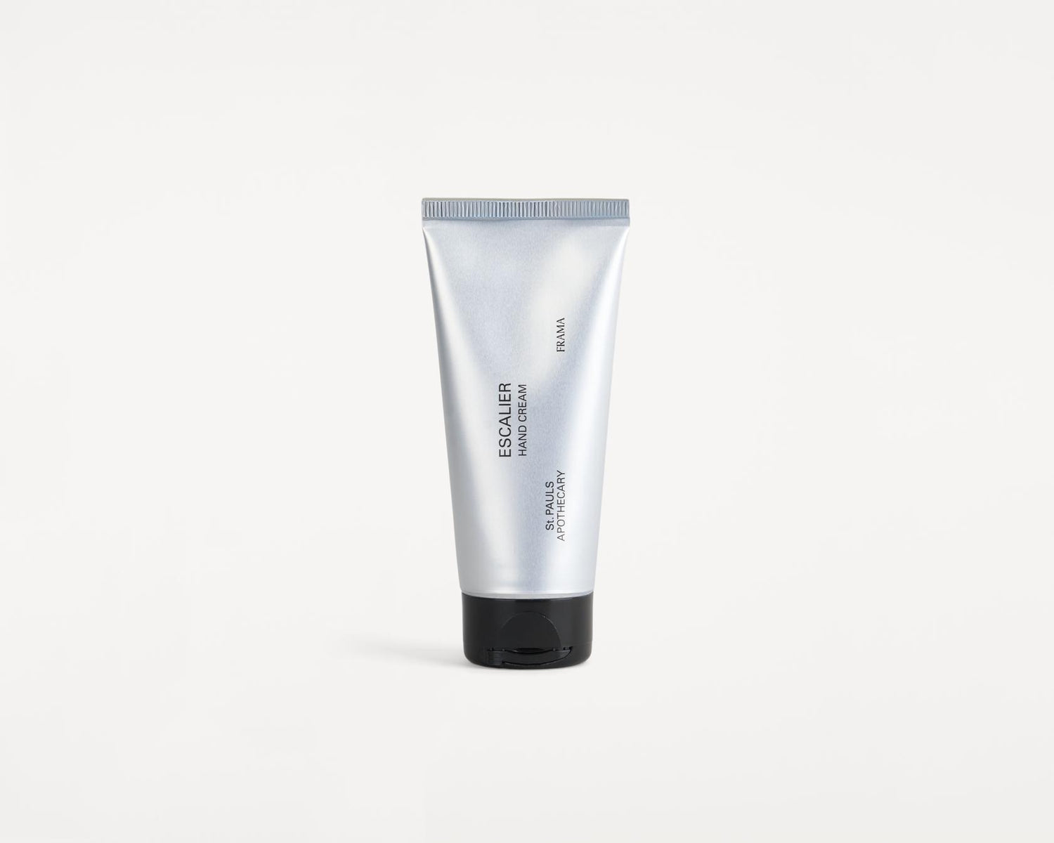 En sølvfarvet tube håndcreme står oprejst mod en hvid baggrund. Teksten "ESCALIER HAND CREAM", "FRAMA" og "ST. PAULS APOTHECARY" er trykt på tuben.
