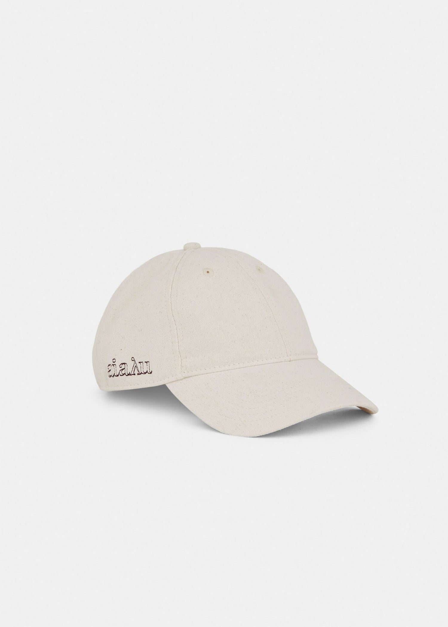 En beige baseballkasket ligger på en hvid baggrund. "aialu" er broderet på siden af kasketten.