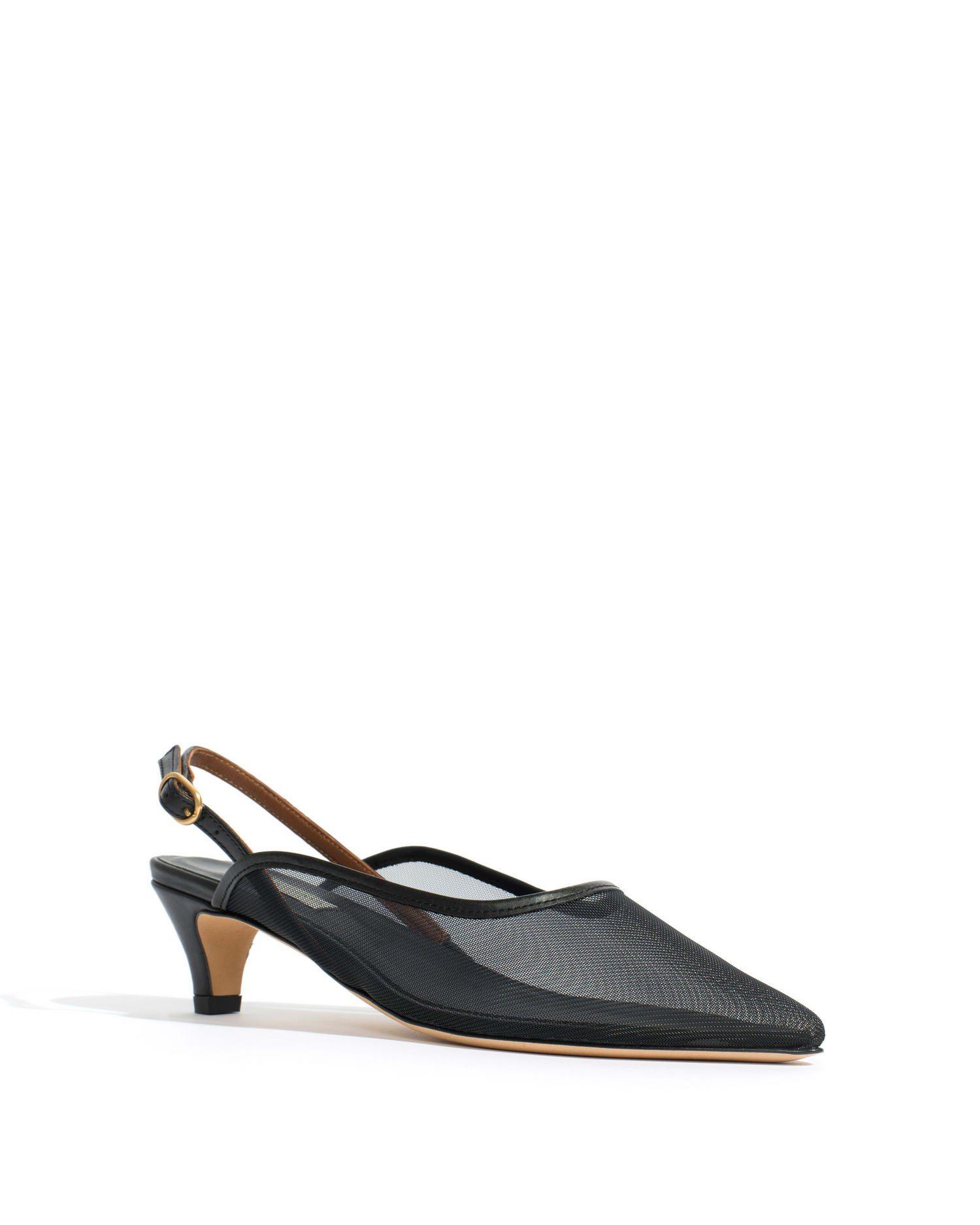 En sort mesh-sko med slingback-rem står på en hvid overflade, og lyset skaber en refleksiv skygge under den.