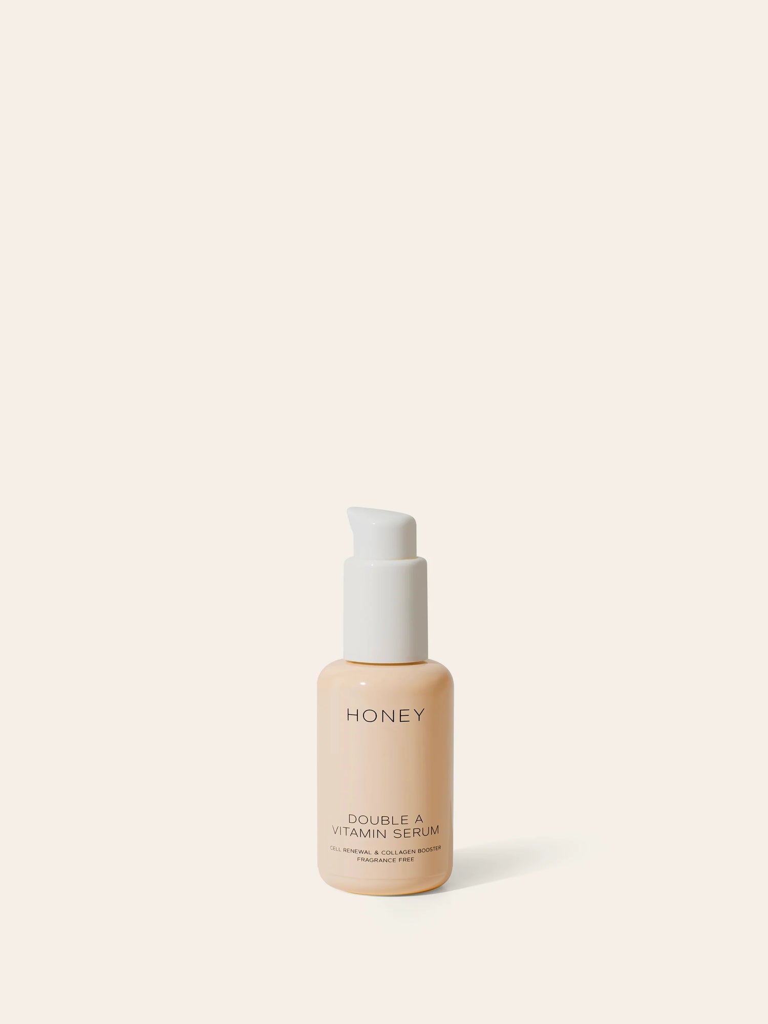 En flaske med lotion står stille på en ensfarvet baggrund. Flaksen har teksten "HONEY DOUBLE A VITAMIN SERUM CELL RENEWAL & COLLAGEN BOOSTER FRAGRANCE FREE".