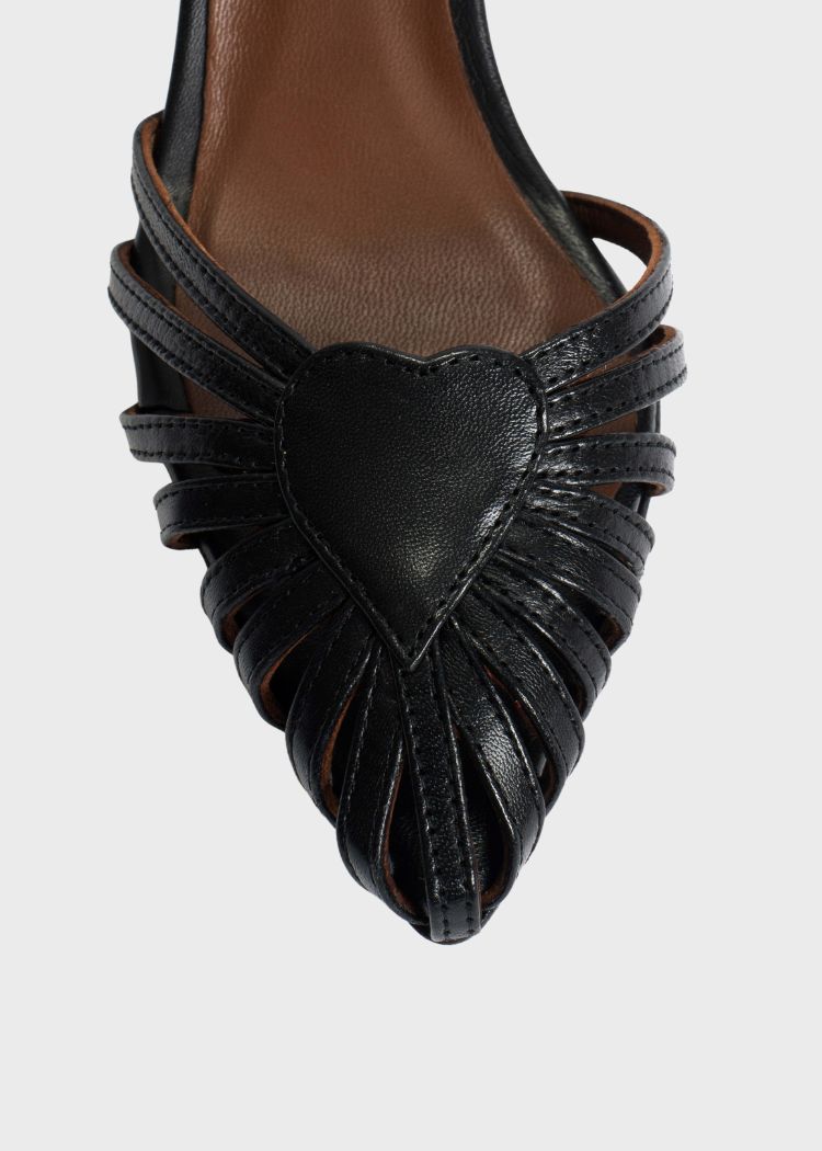 En sort lædersandal fremviser en hjerteformet detalje på forfoden, med smalle remme, der danner et åbent fletmønster på en lys baggrund.